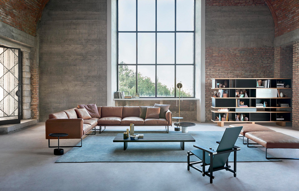 Industrial loft living room with leather sofa, coffee table and large arched window