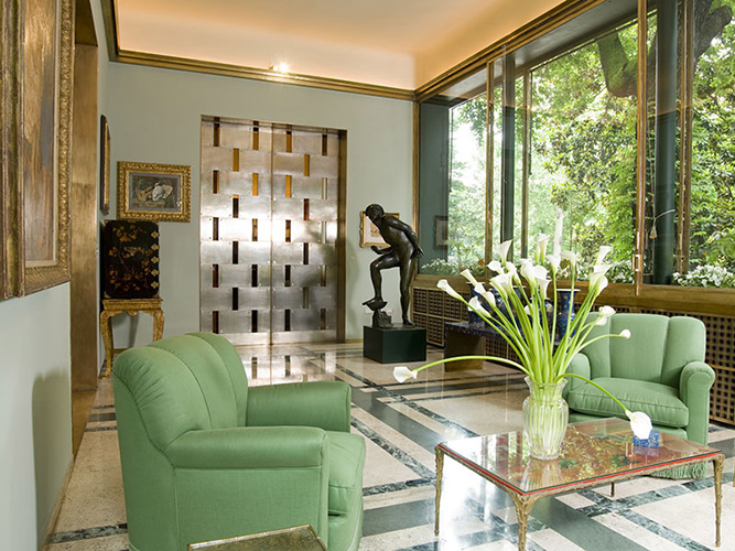 Living room of Villa Necchi in Milan, with green armchairs and a marble floor