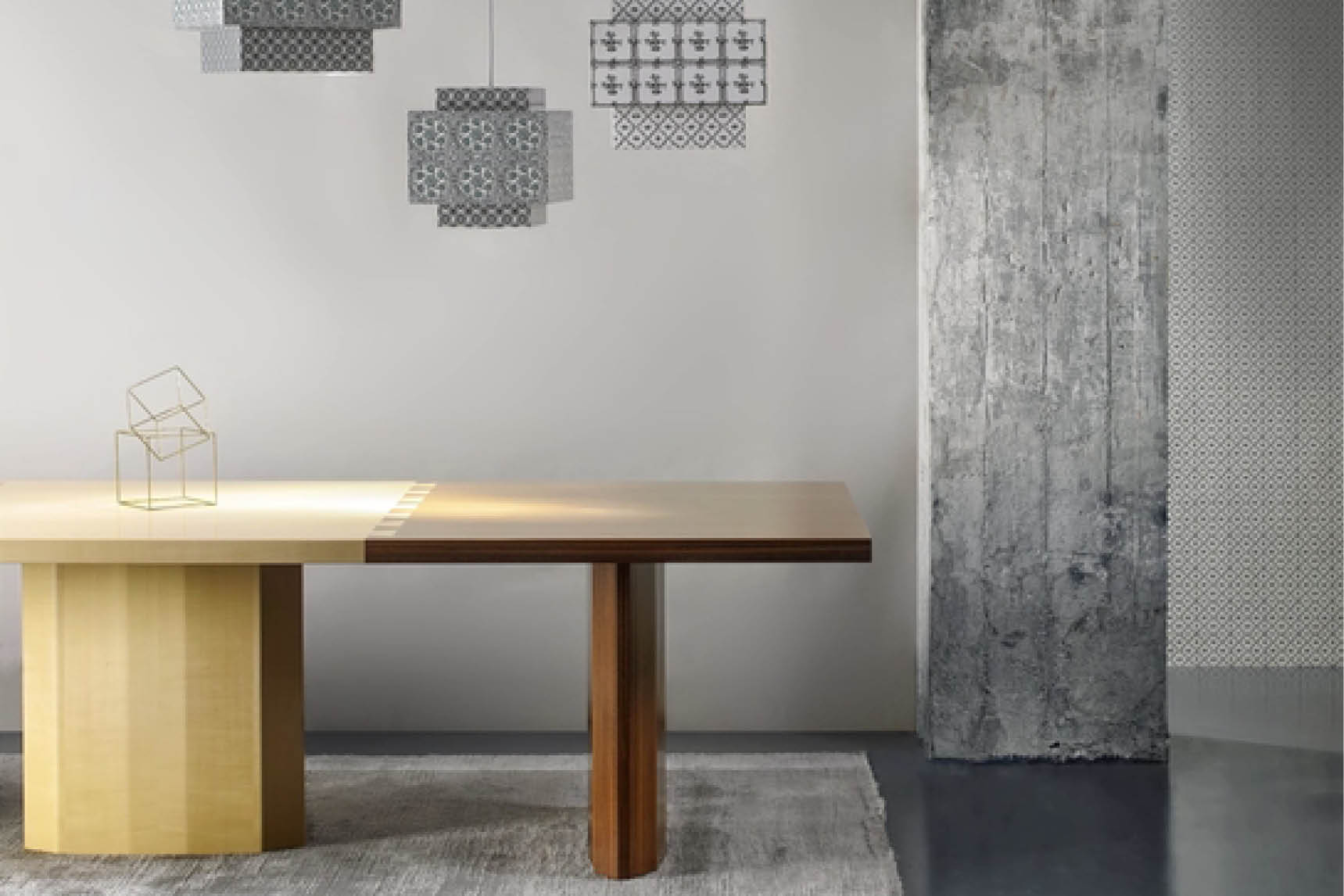 Wooden dining table with a two-tone top in a room with concrete and patterned walls