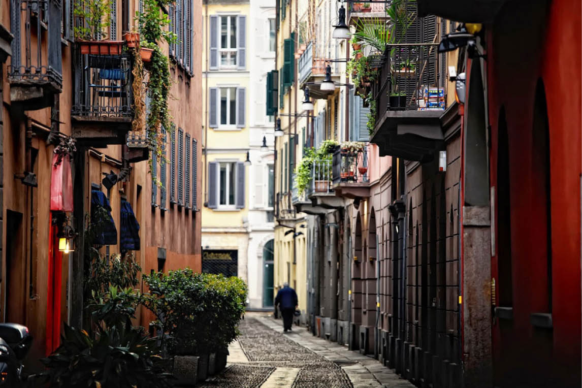 Narrow cobbled street with balconies and plants