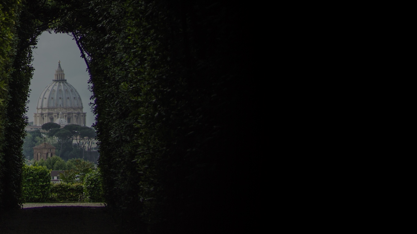 Distant dome of St Peter's Basilica framed through a trimmed hedge archway