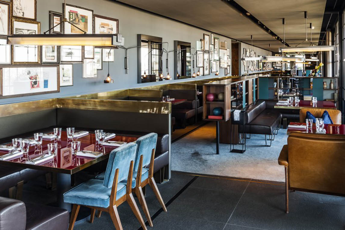 Restaurant with blue chairs and framed pictures on the walls