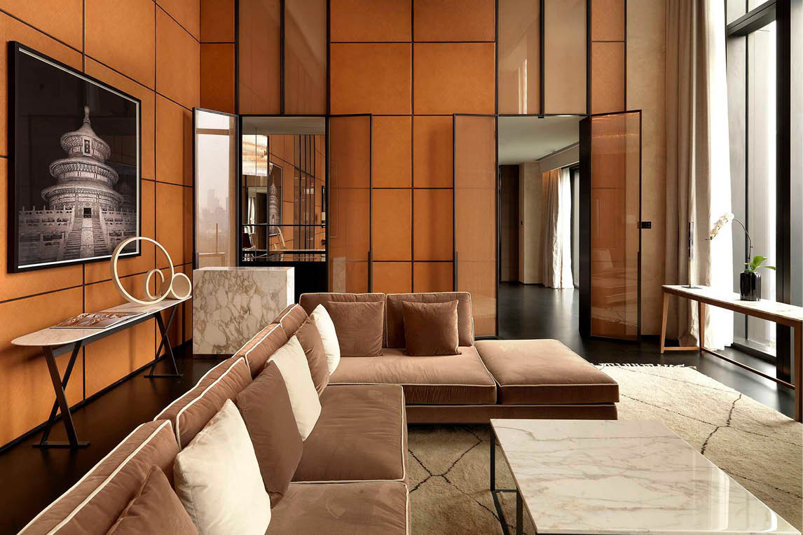 Hotel lounge with a caramel sofa and wood-panelled walls
