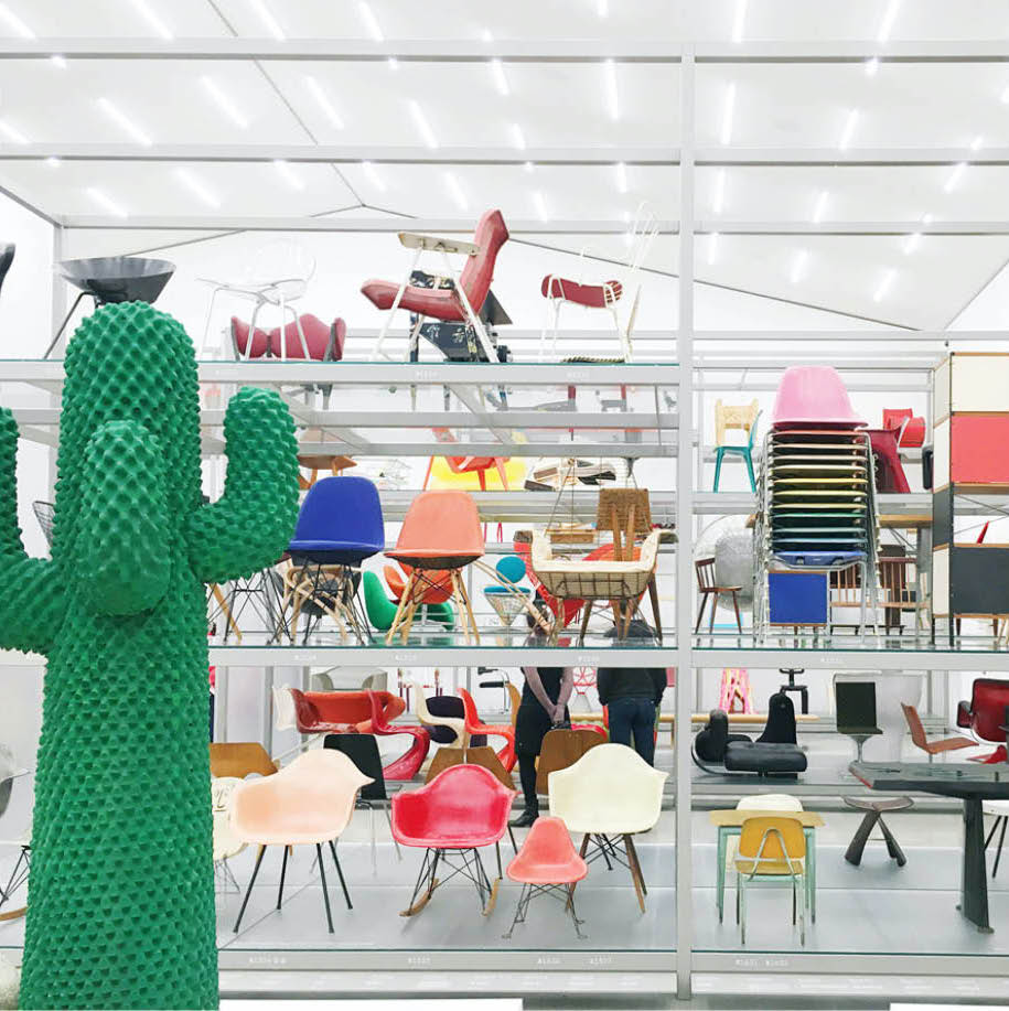 Showroom with colourful designer chairs and a green cactus-shaped coat stand