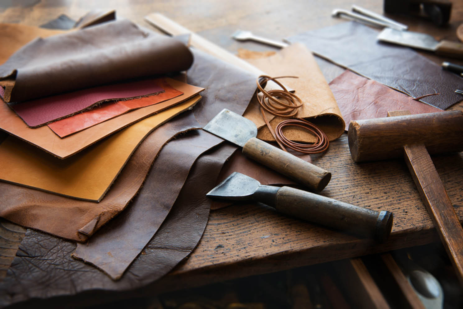 Leather hides and leatherworking tools on a workbench