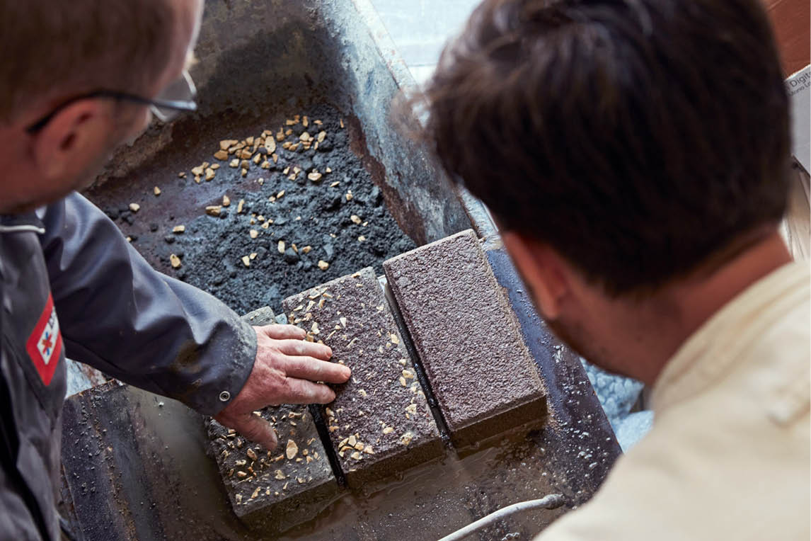 Two craftsmen examining terrazzo-style stone blocks