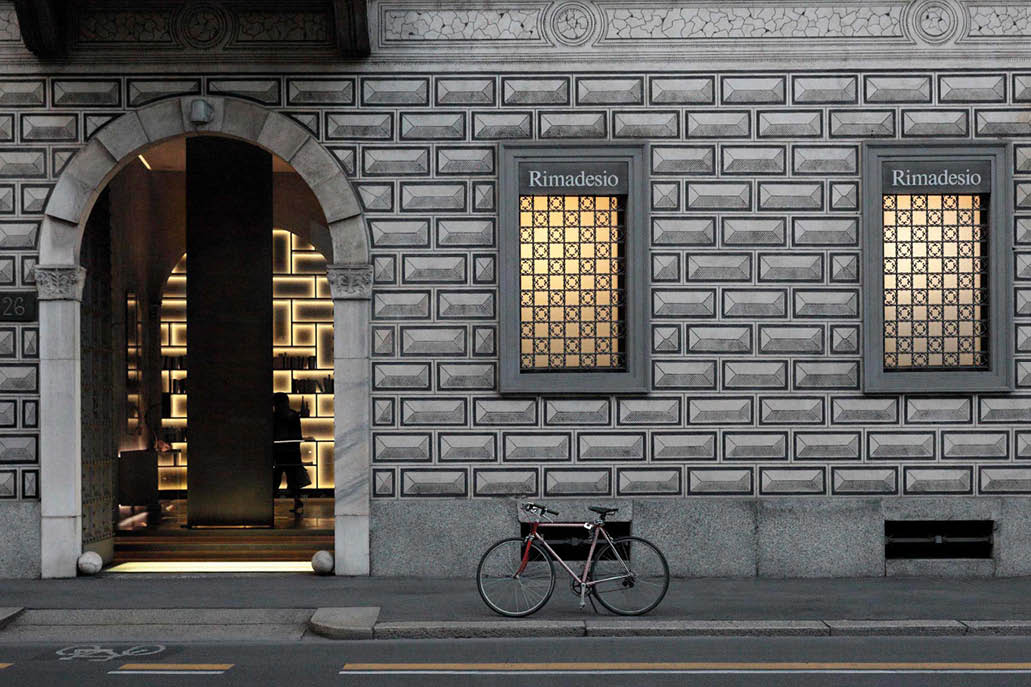 Showroom entrance in a rusticated stone building, with a bicycle outside