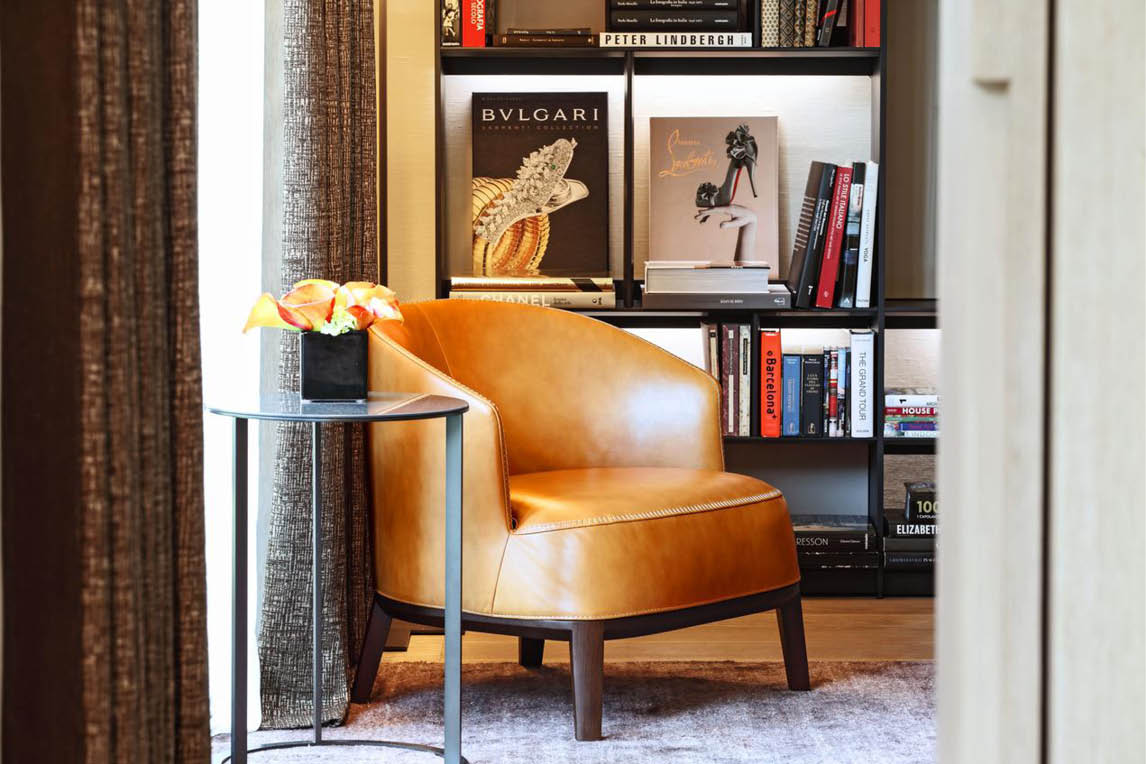 Leather armchair next to a bookcase in a hotel room