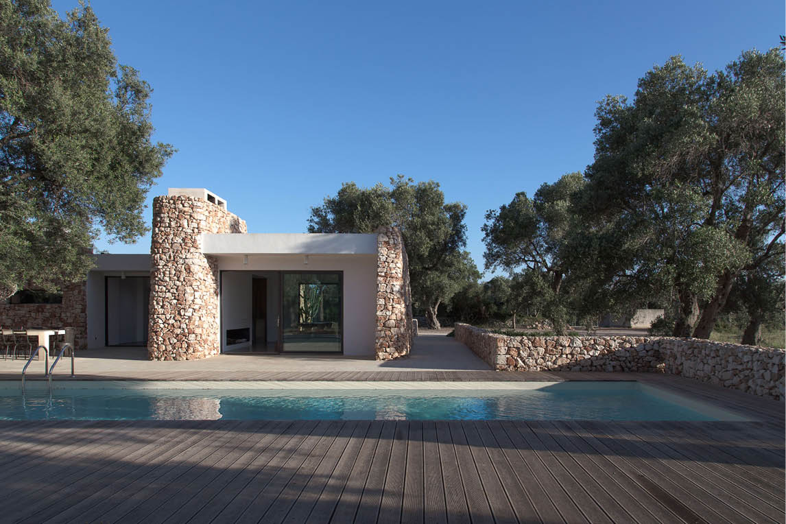 Single-storey villa with stone walls and a pool among olive trees