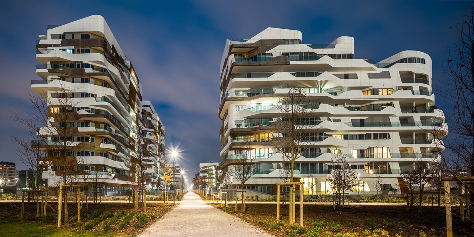 Modern curved apartment towers illuminated at night