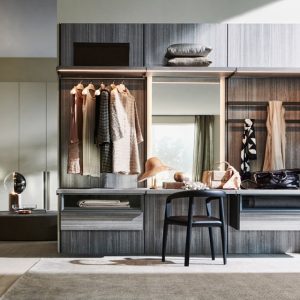 Walk-in closet with wood-toned cabinetry, hanging rail, mirror and a small vanity desk