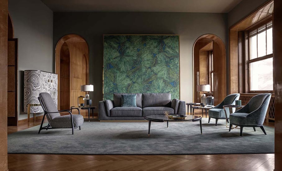 Living room with a grey sofa, patterned green artwork panel and dark green velvet armchairs on a grey rug