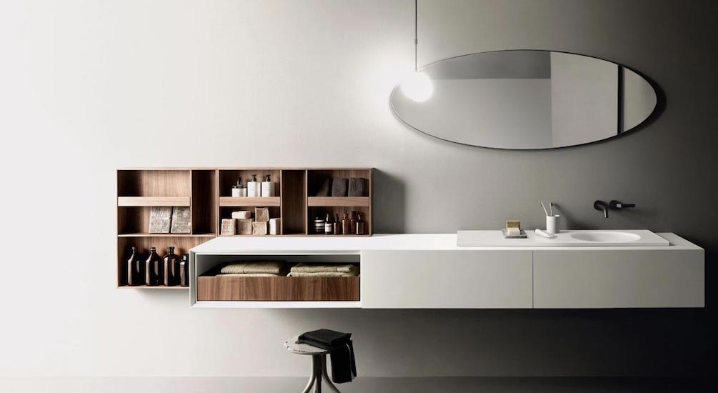 Floating bathroom vanity in white with an oval mirror and walnut wall cabinets