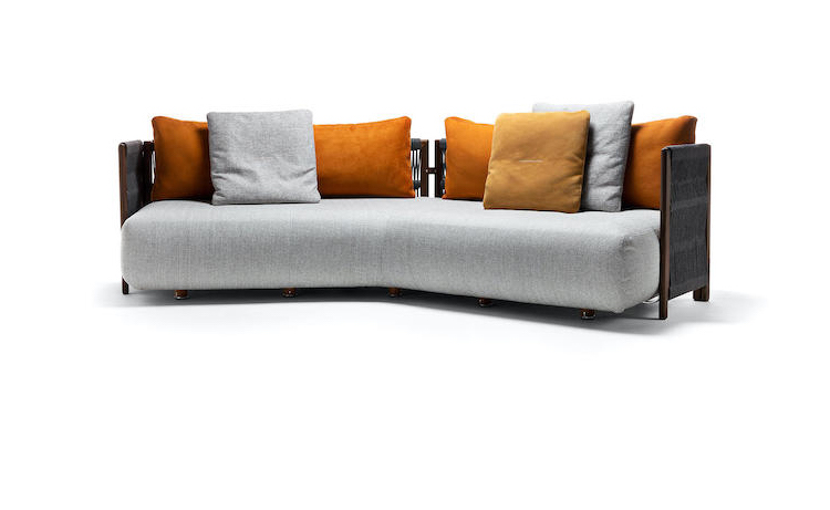 Curved outdoor sofa in grey fabric with orange and mustard cushions